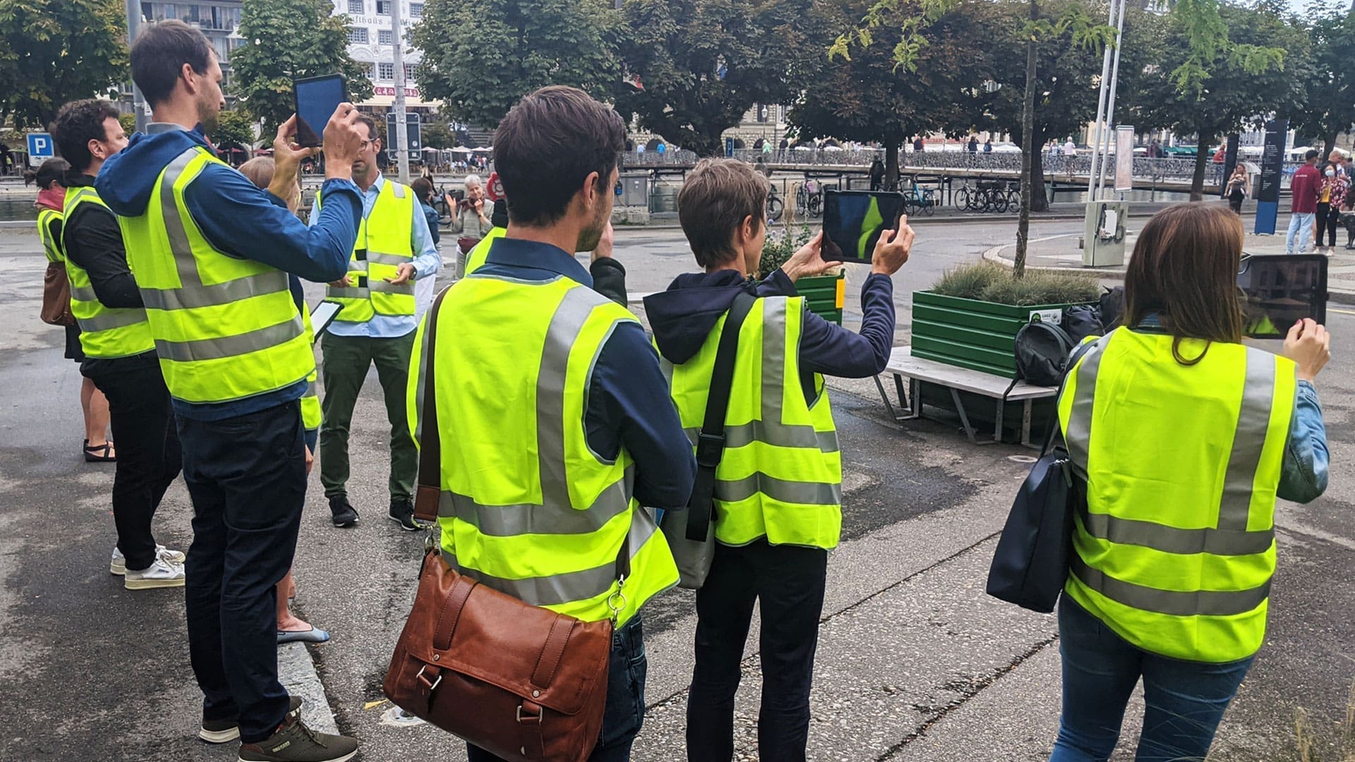 Eine Gruppe von Workshopteilnehmer:innen in Leuchtwesten testet die AR-Anwendung an der Bahnhofstrasse Luzern