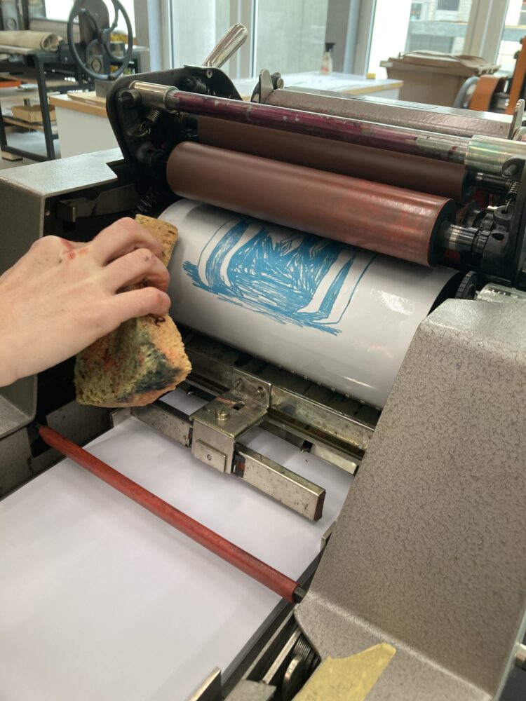 Rotaprint RT4, Hand mit Schwamm, Blick auf Druckplatte auf der Walze